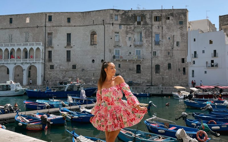 Girl with a flowery dress posing in the harbour in Monopoli, Puglia